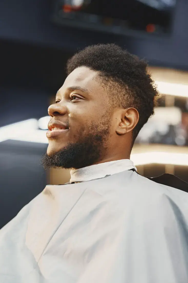 A smiling guest in the chair after his haircut